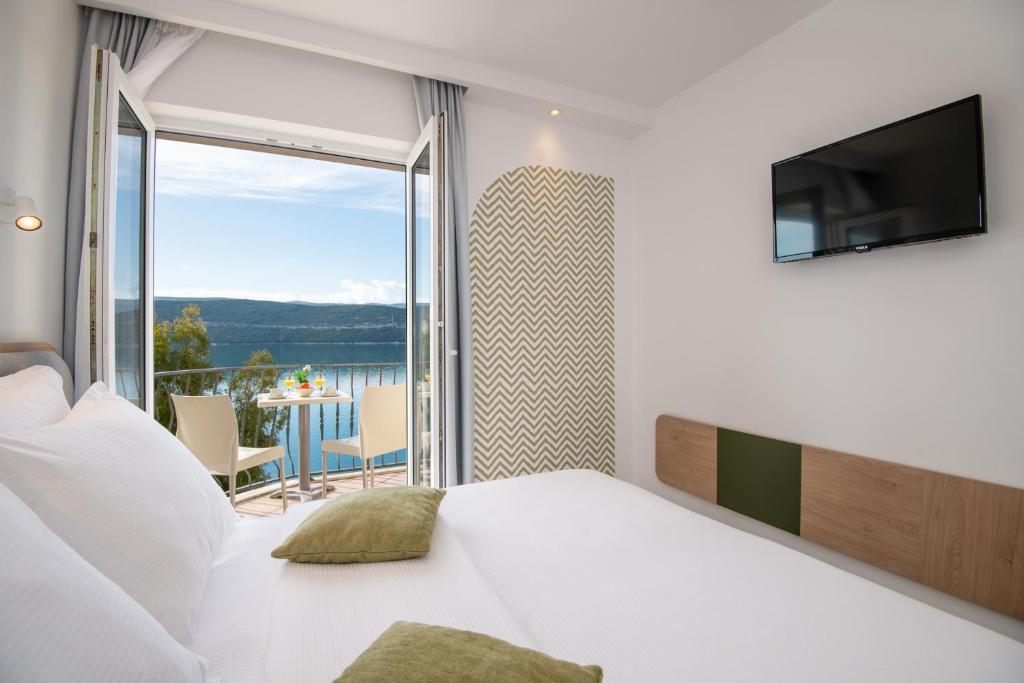 1 dormitorio con cama y vistas a un balcón en Hotel Villa Nova, en Neum