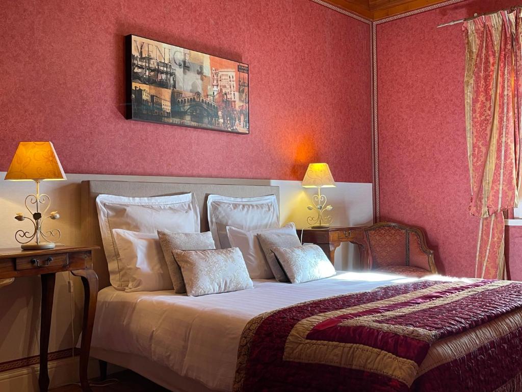 ein Schlafzimmer mit einem großen Bett mit rosa Wänden in der Unterkunft Chateau Du Payre in Cardan