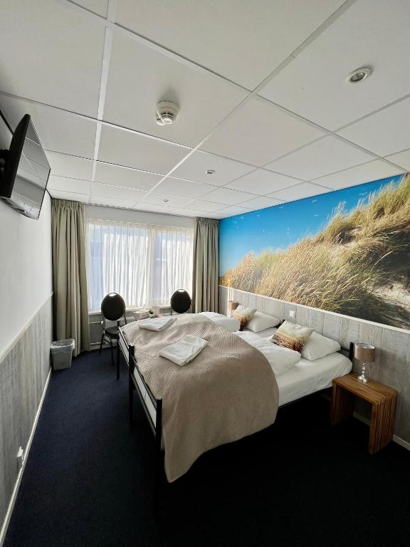 una camera d'albergo con due letti e un dipinto di una spiaggia di SEA YOU Hotel Noordwijk a Noordwijk aan Zee