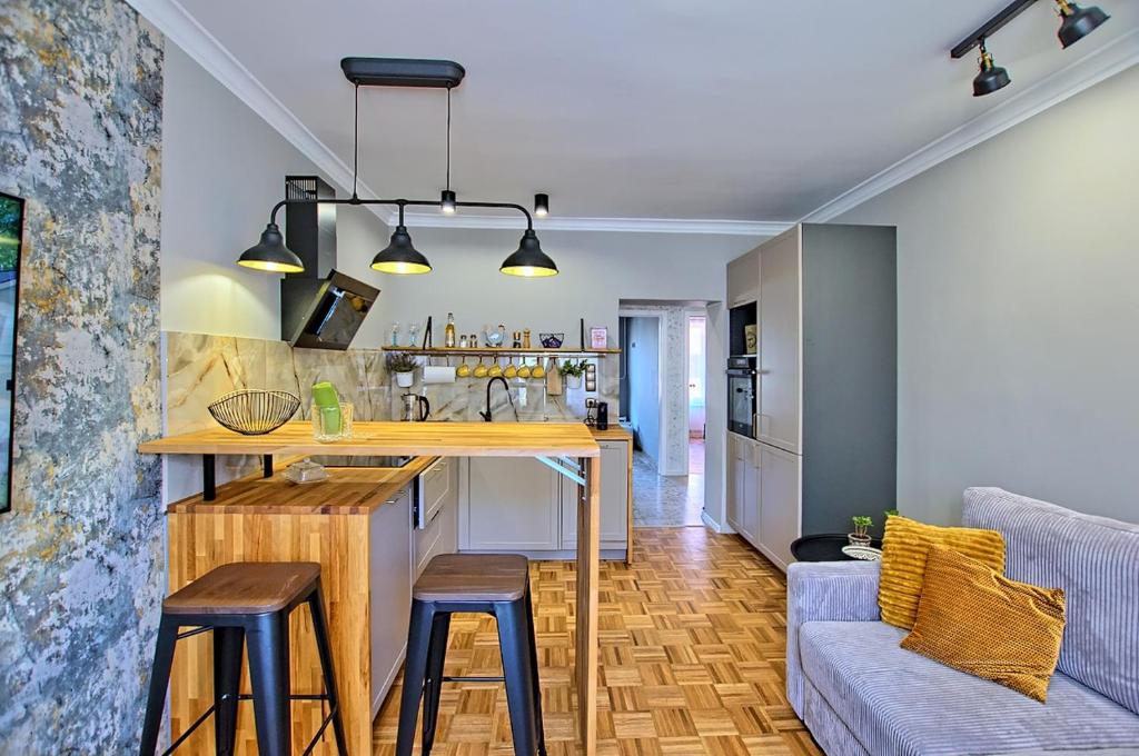a kitchen and living room with a counter and stools at Apartament Lipova in Piechowice