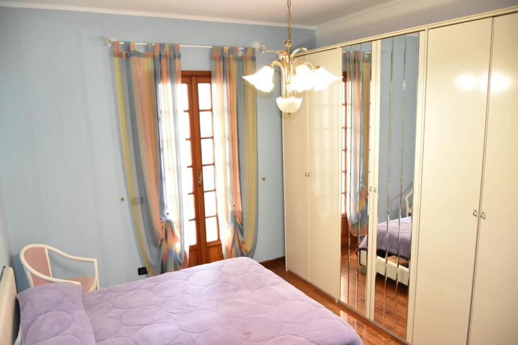 ein Schlafzimmer mit einem lila Bett und einem Spiegel in der Unterkunft Casa Lulù in Riva Ligure