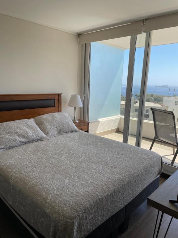 a bedroom with a bed and a large window at Departamento Plaza Mexico in Viña del Mar