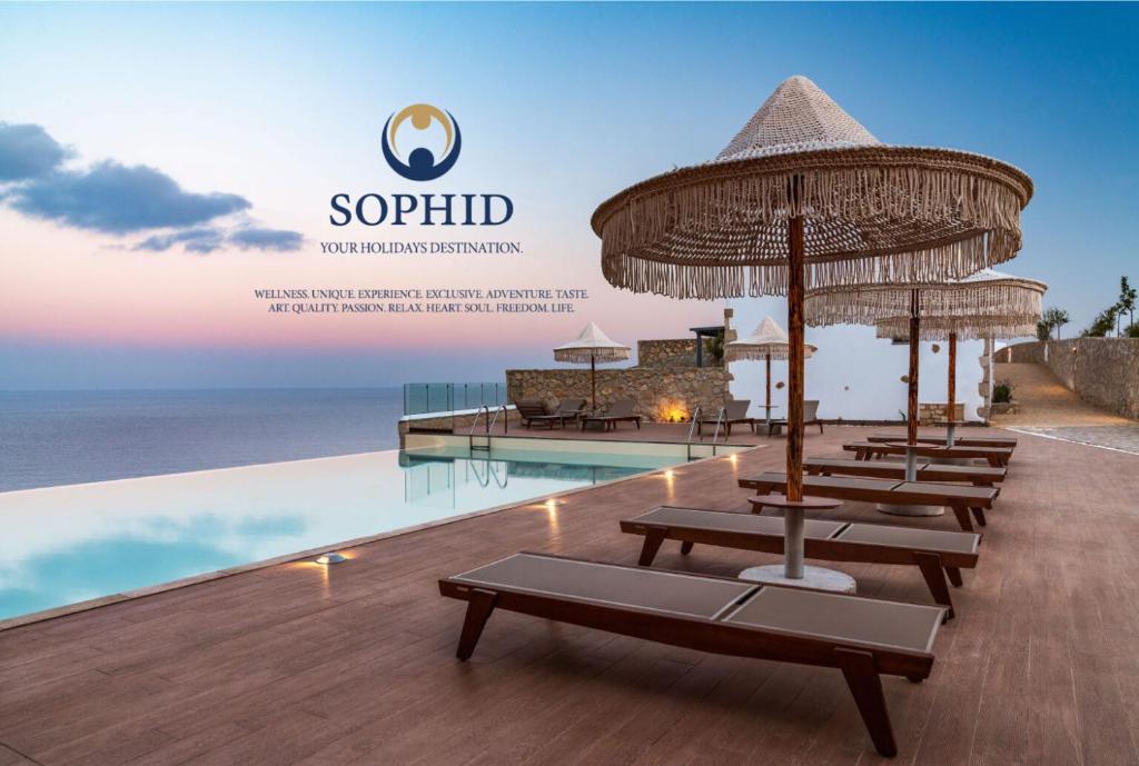 a row of chairs with umbrellas next to a pool at SOPHID Wellness Suites Karpathos in Karpathos