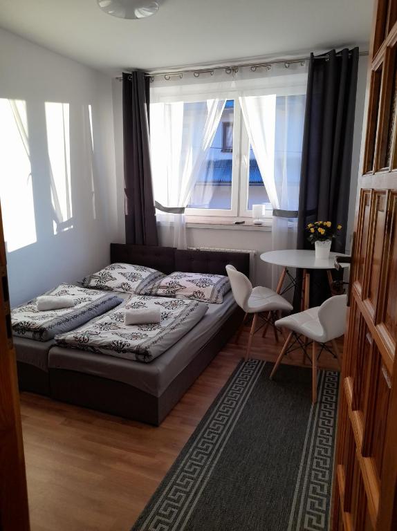 a bedroom with a bed and a table and chairs at Na Górce W Białym Dunajcu in Biały Dunajec