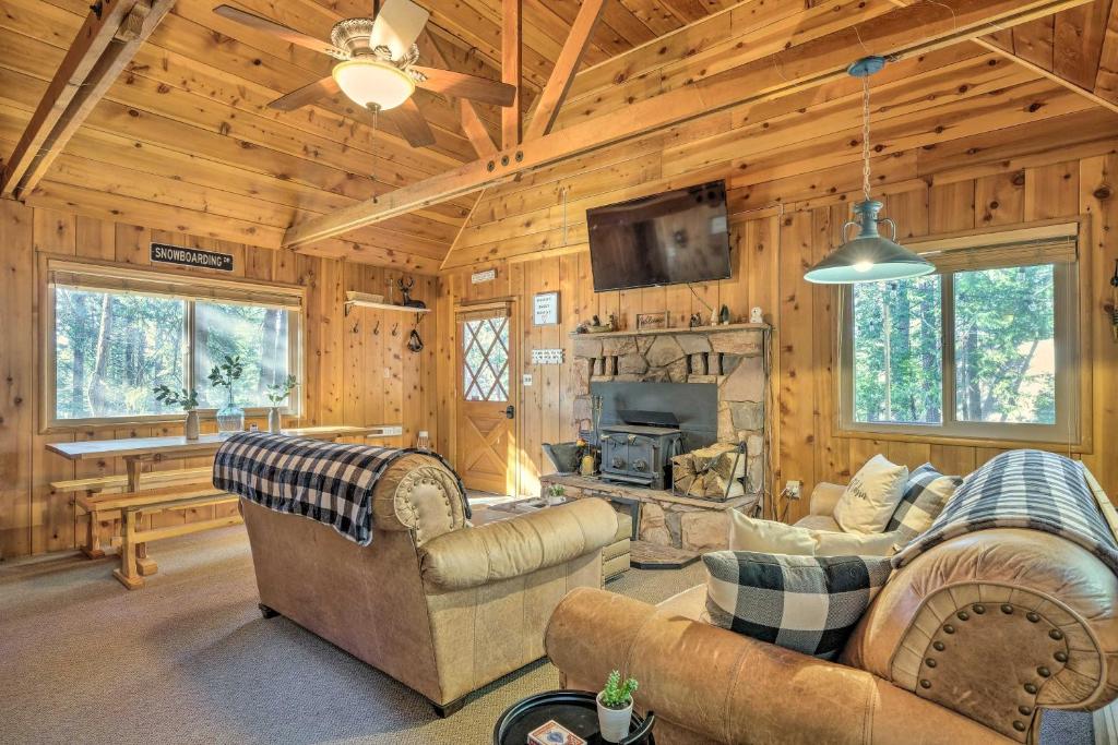 ein Wohnzimmer mit Sofas und einem Kamin in einer Blockhütte in der Unterkunft Cozy Cabin about 3 Mi to Big Trees State Park! in Arnold