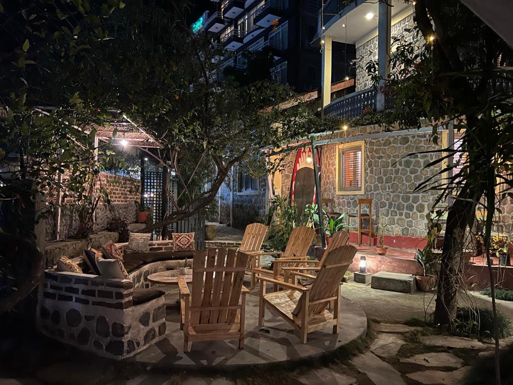 a patio with chairs and a table and a fire place at Gaurishankar Backpackers hostel in Pokhara