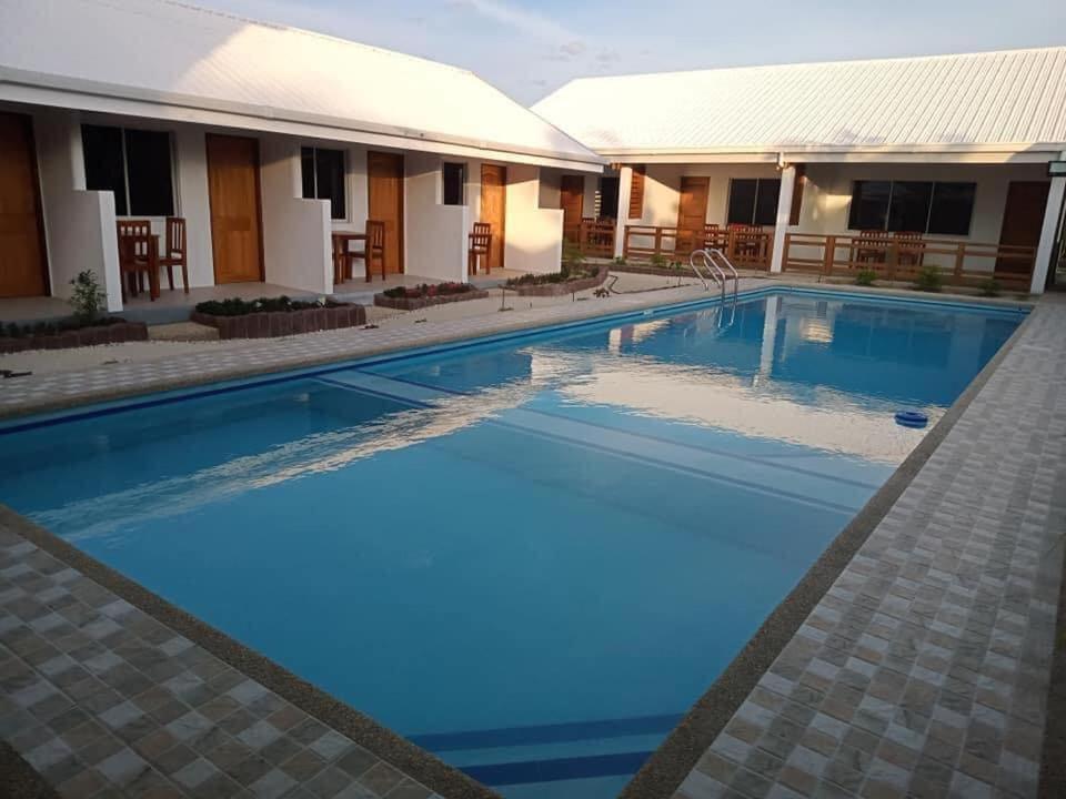 een groot zwembad met blauw water voor een gebouw bij Badi's Place in Moalboal