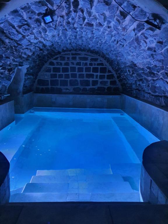 a swimming pool with blue lights in a brick wall at Lake Mansion in Tiberias