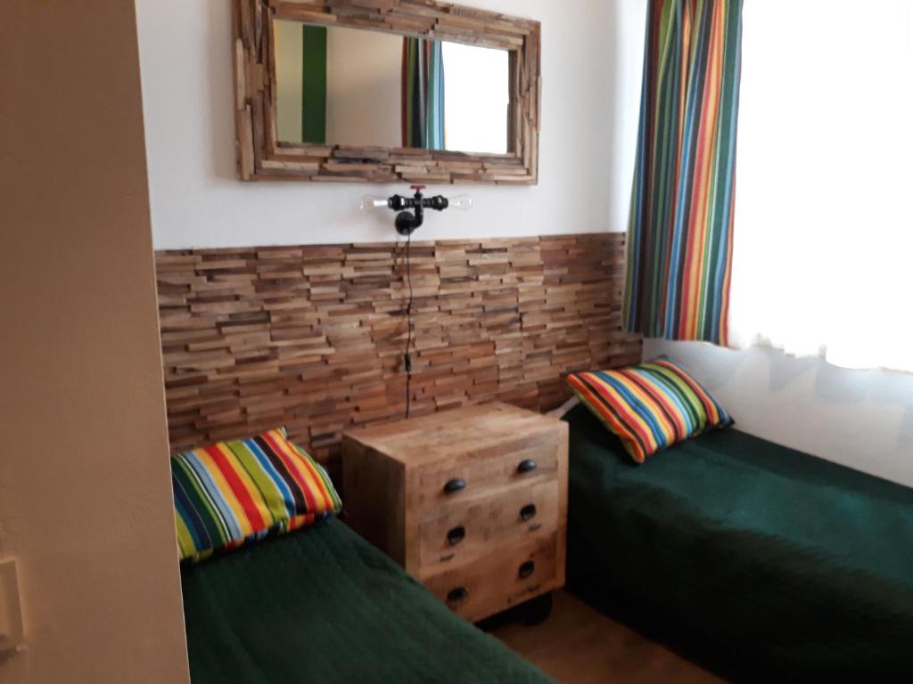 Pokój z 2 zielonymi łóżkami i lustrem w obiekcie Wioska pod Kogutem w mieście Krępa