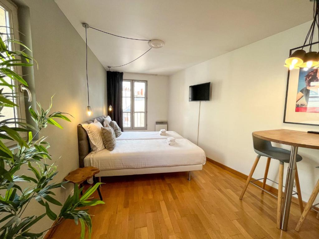 a room with a bed and a table in it at 501 - Charmant studio dans un immeuble Paris 5 in Paris