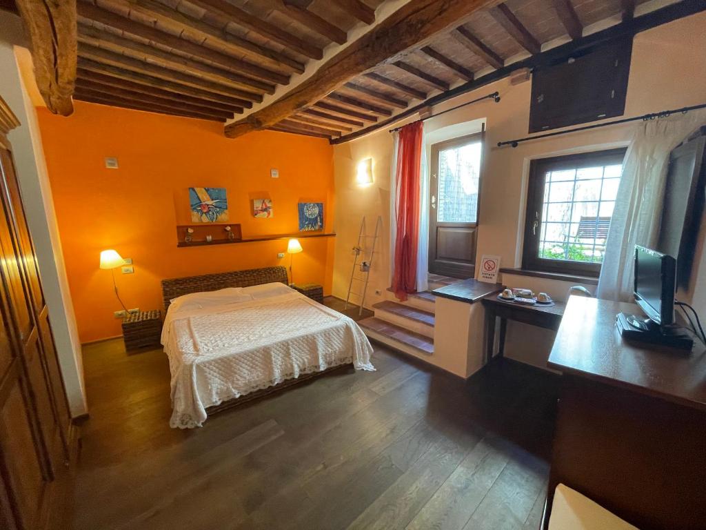 モンテプルチャーノにあるDimora Del Corso Di Montepulcianoのオレンジ色の壁のベッドルーム1室(ベッド1台付)
