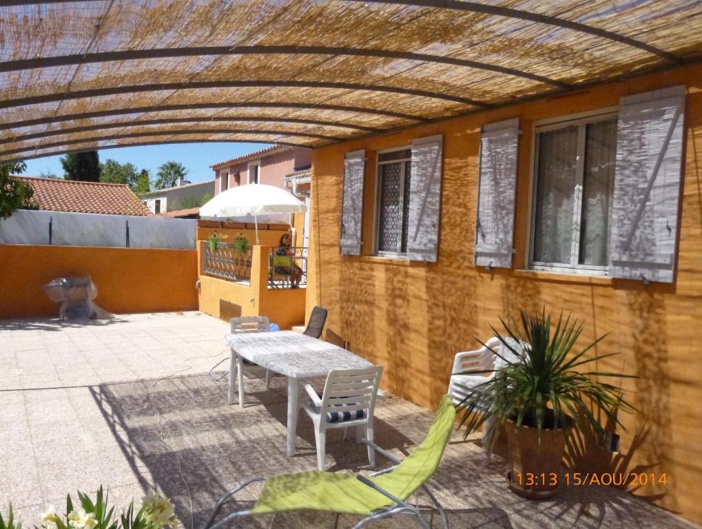 a patio with a table and chairs and a building at La Maison de Marguerite in Cassis