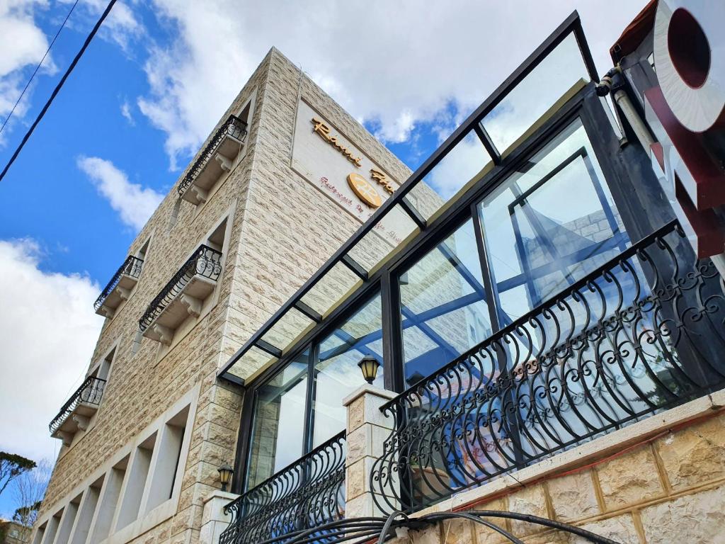 a building with a balcony on the side of it at Rami Hotel in Fālūghā