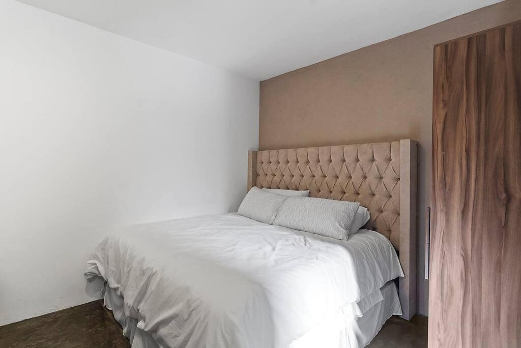 een slaapkamer met een groot bed met witte lakens bij +MS +Loft Céntrico +Cómodo +Internet 119G in Casa Blanca La Corregidora
