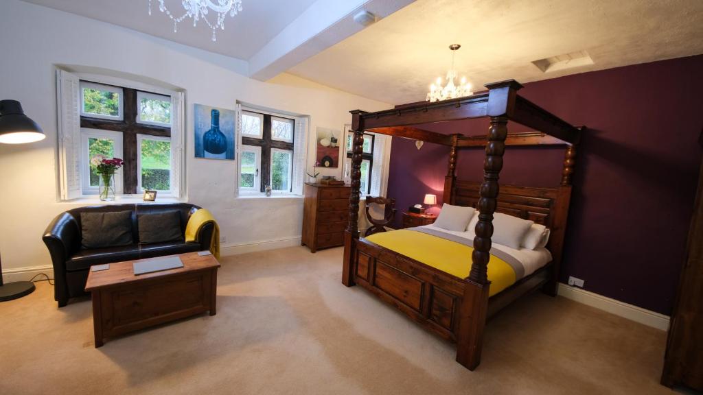 - une chambre avec un lit à baldaquin et une chaise dans l'établissement Rowrah Hall, à Arlecdon