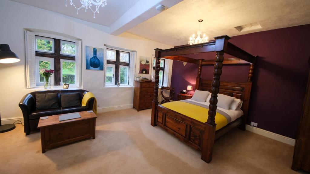 a bedroom with a canopy bed and a chair at Rowrah Hall in Arlecdon