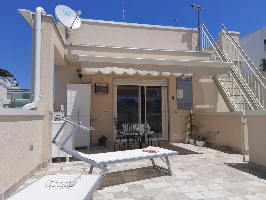 eine Terrasse mit einer Bank und einem Tisch auf einem Haus in der Unterkunft Casa Van Westerhout in Mola di Bari
