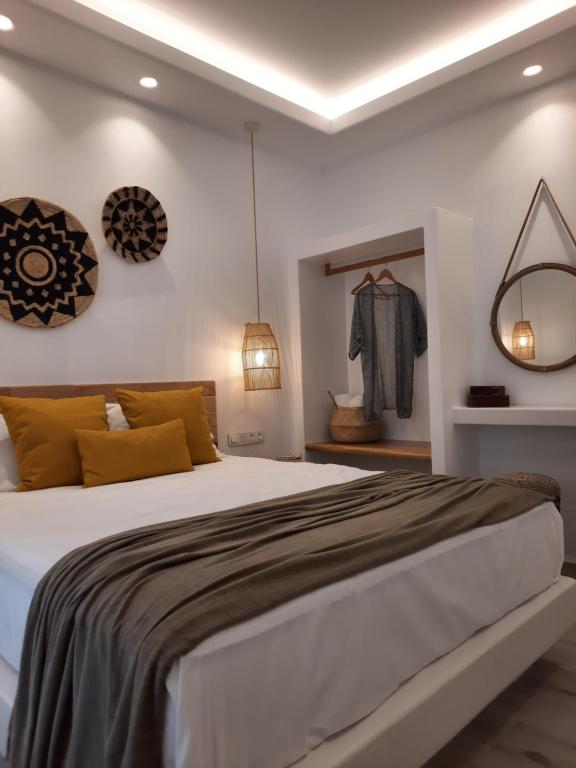 een slaapkamer met een groot wit bed met gele kussens bij Konstantza's Superior Suite in Naxos Chora