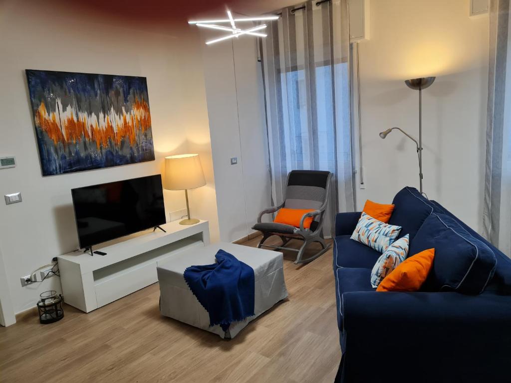a living room with a blue couch and a tv at aria di mare in Sestri Levante