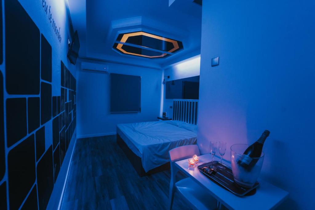 a blue room with a bed and a bottle of wine at Motel Príncipe Encantado in Mealhada