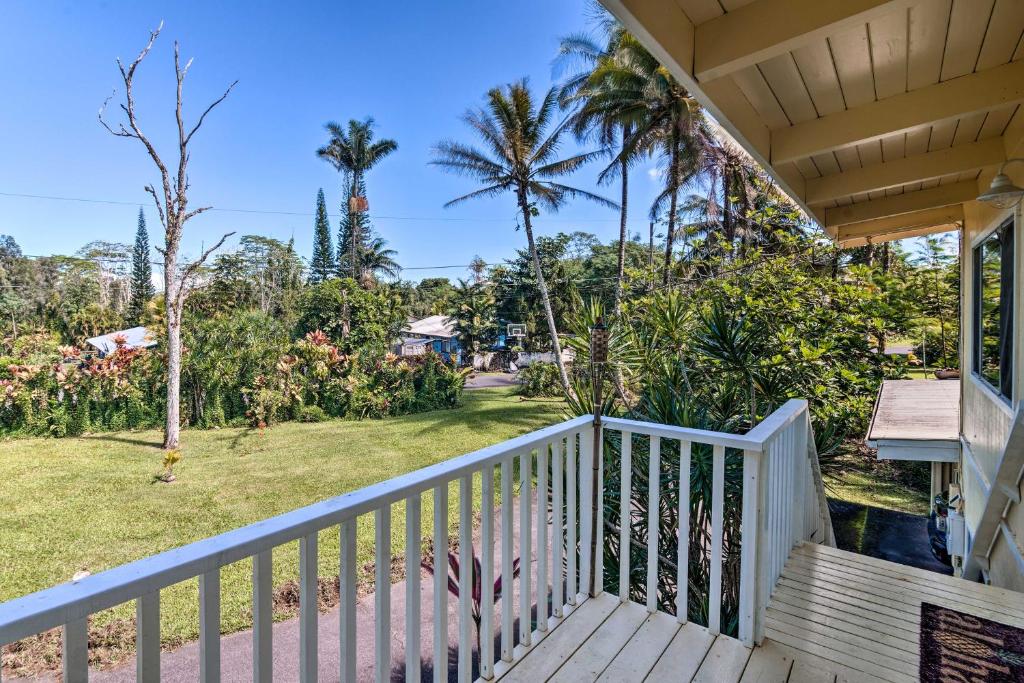 un balcón de una casa con palmeras y un patio en Sunny Pahoa Retreat Snorkel, Hike and Shop!, en Pahoa