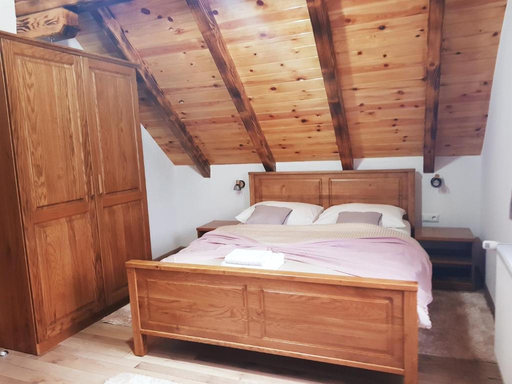 a bedroom with a wooden bed and wooden ceilings at Plitvice Green Valley in Plitvička Jezera