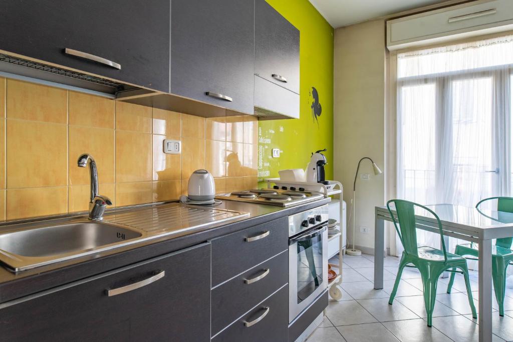 cocina con fregadero y mesa con sillas en Casa Porta Pila, en Turín