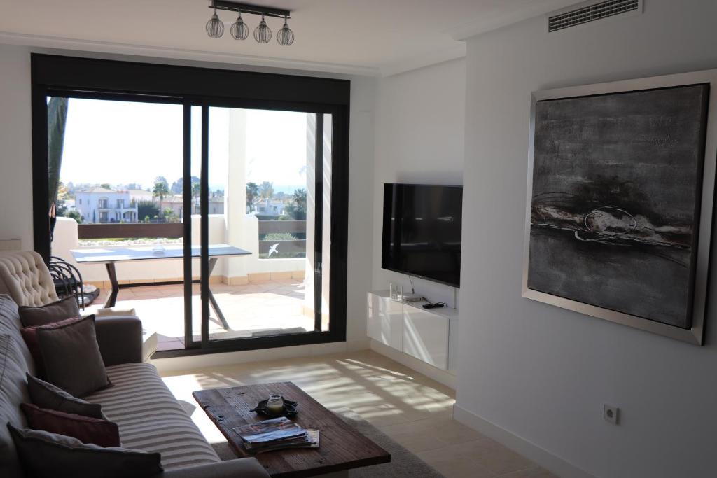 TV a/nebo společenská místnost v ubytování Sunset Resina Golf - 2 Bedrooms Apartment with Sea view - Estepona