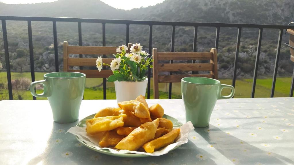 talerz jedzenia na stole z dwoma kubkami w obiekcie Apartamento Rural Bella Vista w mieście Villaluenga del Rosario
