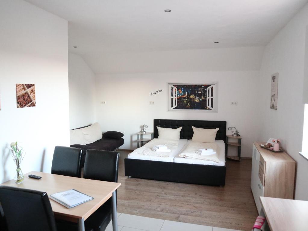 1 dormitorio con 1 cama, mesa y sillas en Gästehaus Radler Scheune en Heede