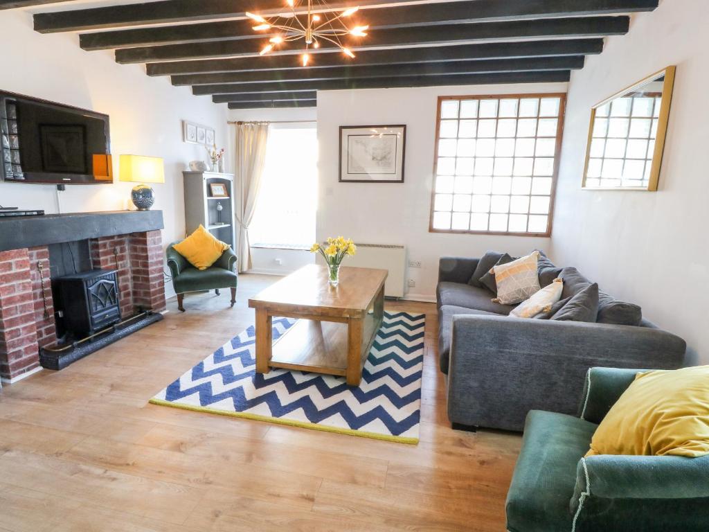 a living room with a couch and a table at Malltraeth Cottage in Bodorgan