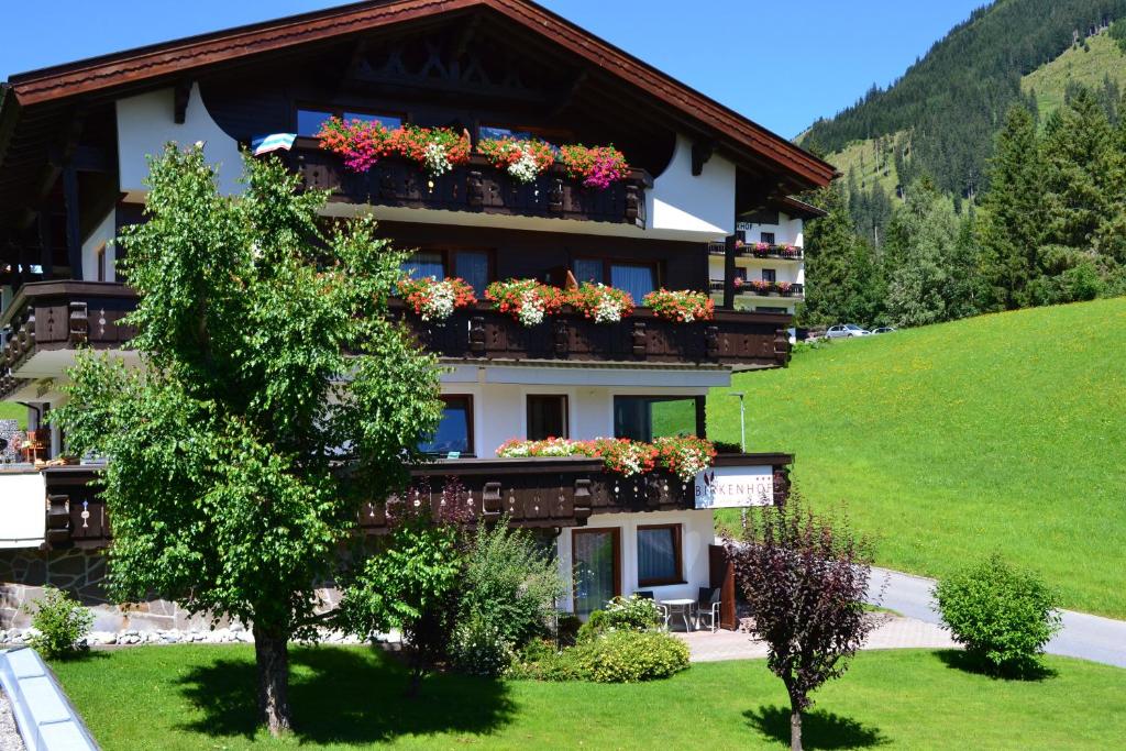 a building with flower boxes on the side of it at BIRKENHOF - Premium Apart & Suites in Lermoos