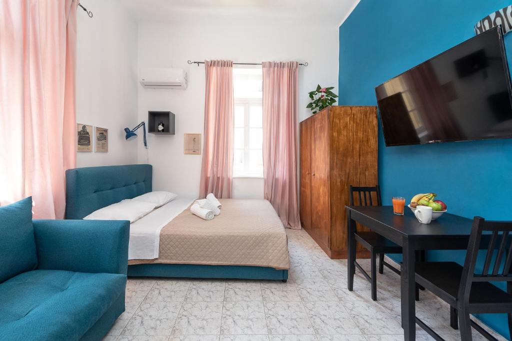 a bedroom with a bed and a couch and a table at Classic-Style Apartment Nearby the Old Town in Rhodes Town