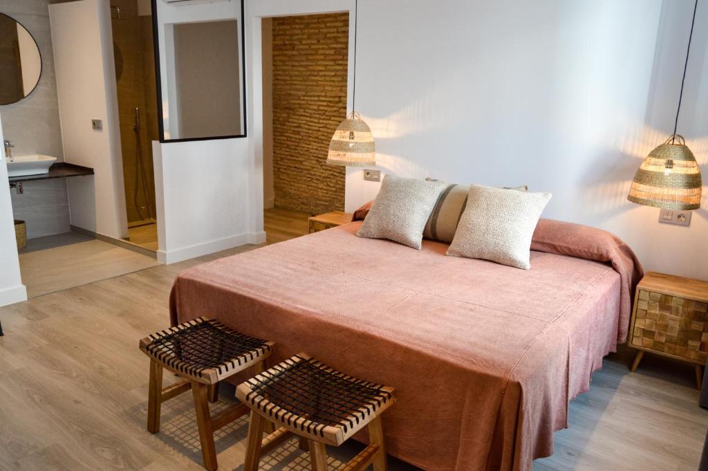 a bedroom with a large bed with two stools at Arena House Conil in Conil de la Frontera