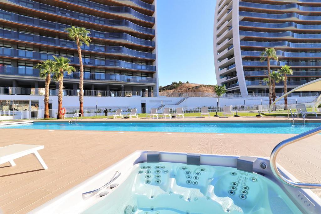 a swimming pool with a hot tub and a building at Sunset Waves 1-2 in Benidorm