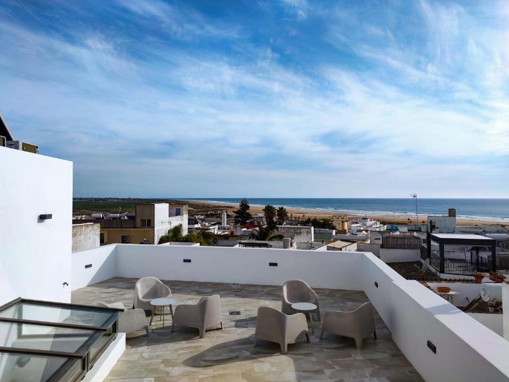 balkon z krzesłami i widokiem na ocean w obiekcie Arena House Conil w mieście Conil de la Frontera