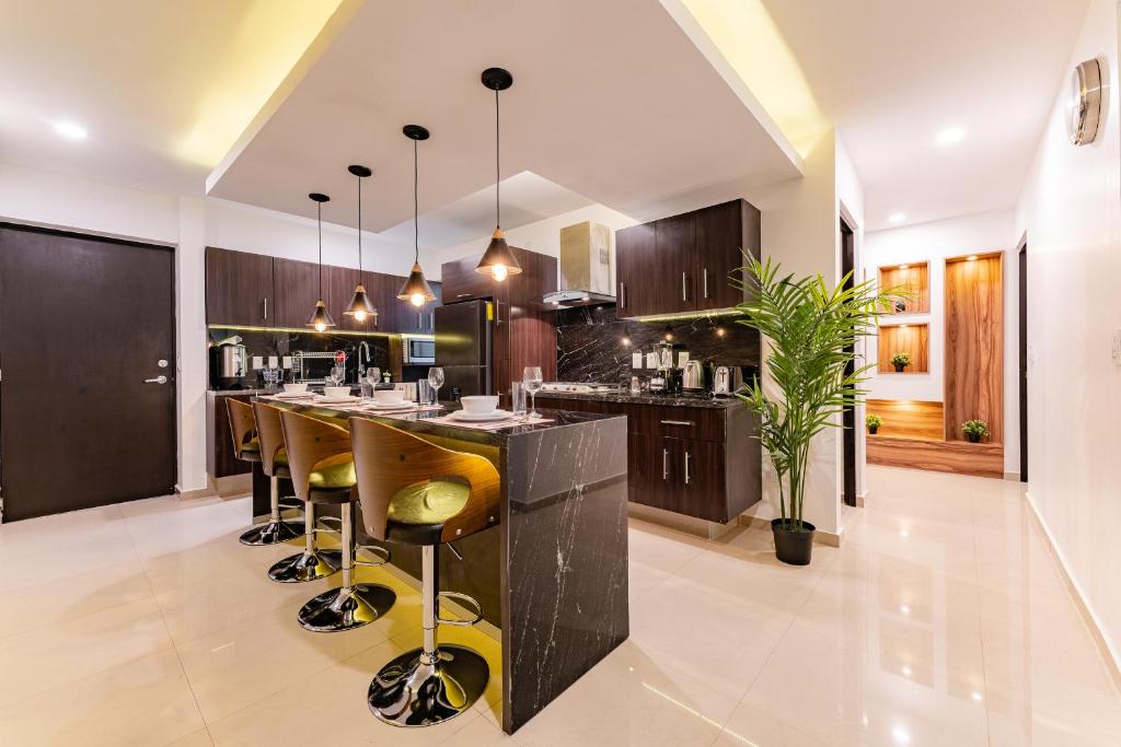 a kitchen with a large island with bar stools at Lujoso apartamento Condesa- Chapultepec in Mexico City