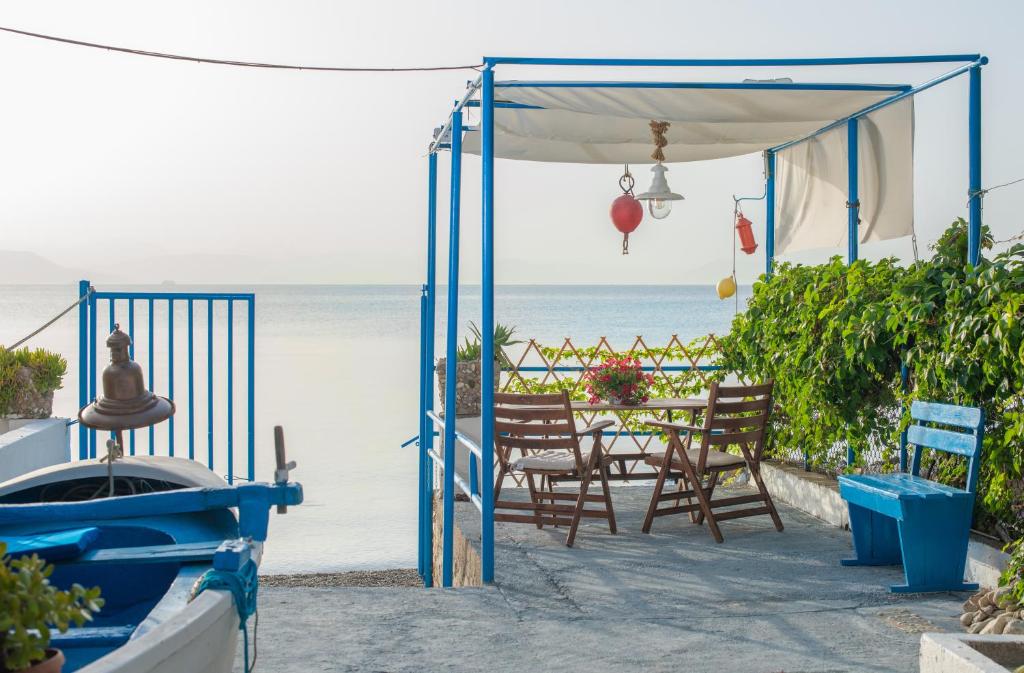 eine Terrasse mit einem Tisch, Stühlen und Meerblick in der Unterkunft Agistri By The Sea in Perama