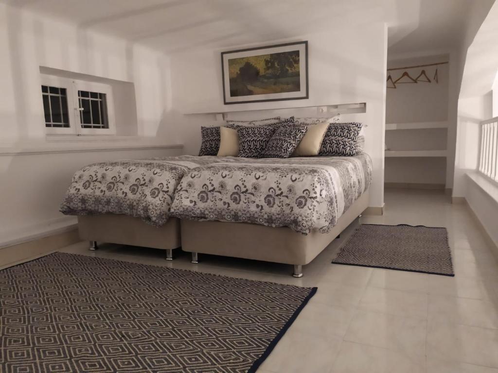 a bedroom with a large bed and a rug at Kalymnos Gallery in Kalymnos