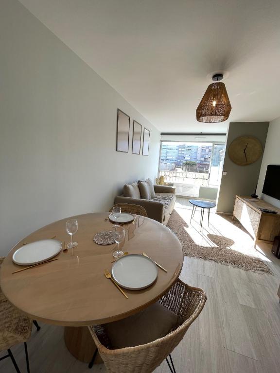 un salon avec une table et un canapé dans l'établissement Le P'tit Carnon, à Mauguio