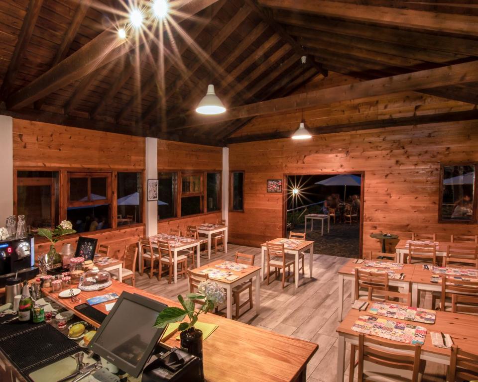 a restaurant with wooden floors and tables and chairs at Aldeia da Cuada in Faja Grande