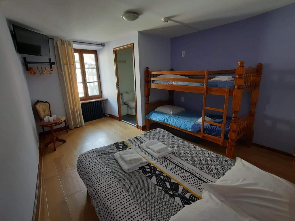 sypialnia z 2 łóżkami piętrowymi w pokoju w obiekcie Hôtel des Voyageurs w mieście Ferrières-Saint-Mary