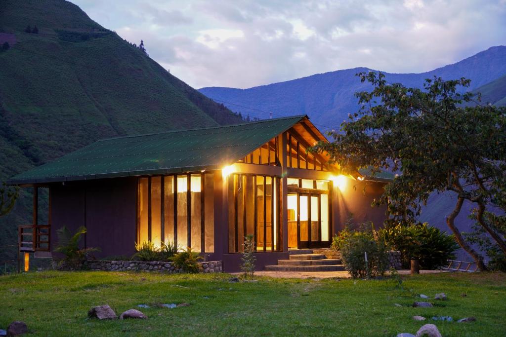 uma pequena casa com montanhas ao fundo em Vertikal lodge em Santa Teresa