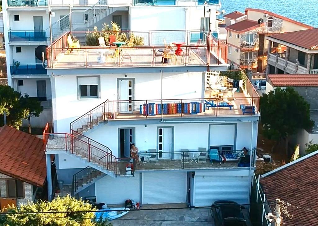 ein weißes Apartmenthaus mit Balkon und Wasser in der Unterkunft Apartments Apartmani Bojana in Utjeha