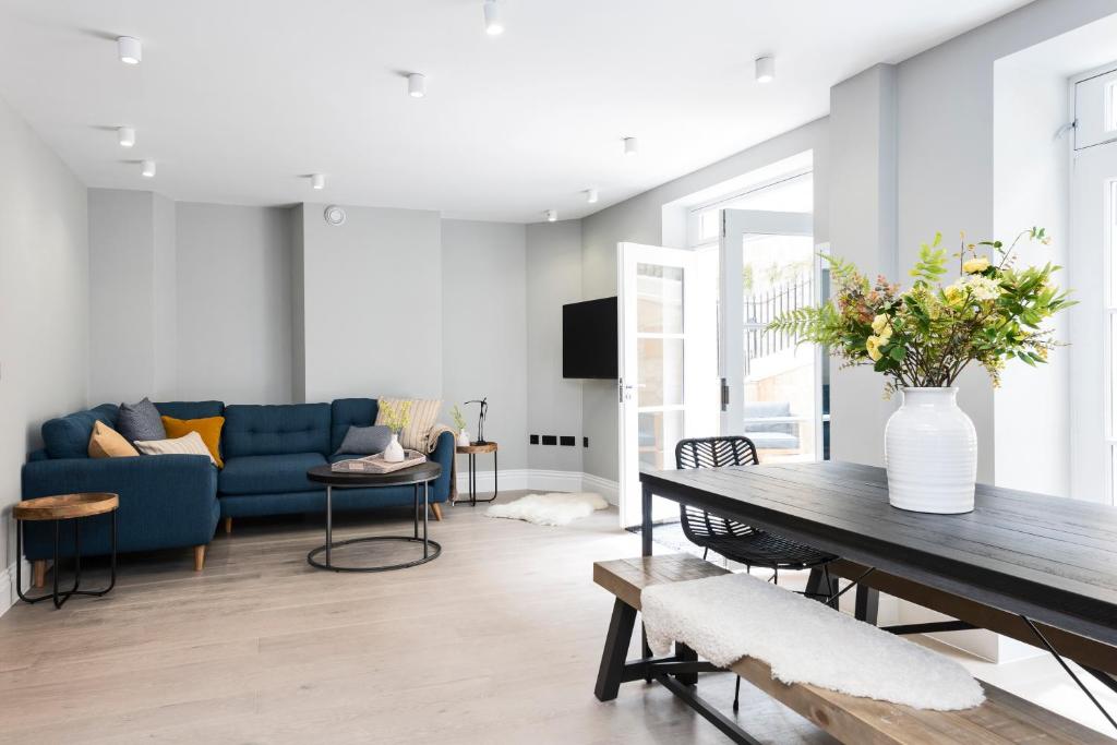 uma sala de estar com um sofá azul e uma mesa em Wine Vaults Apartment em Bath