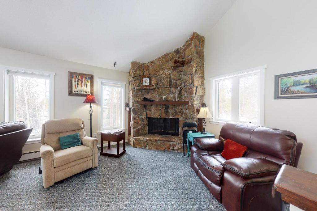 a living room with a couch and a stone fireplace at Misty Meadow in Fraser