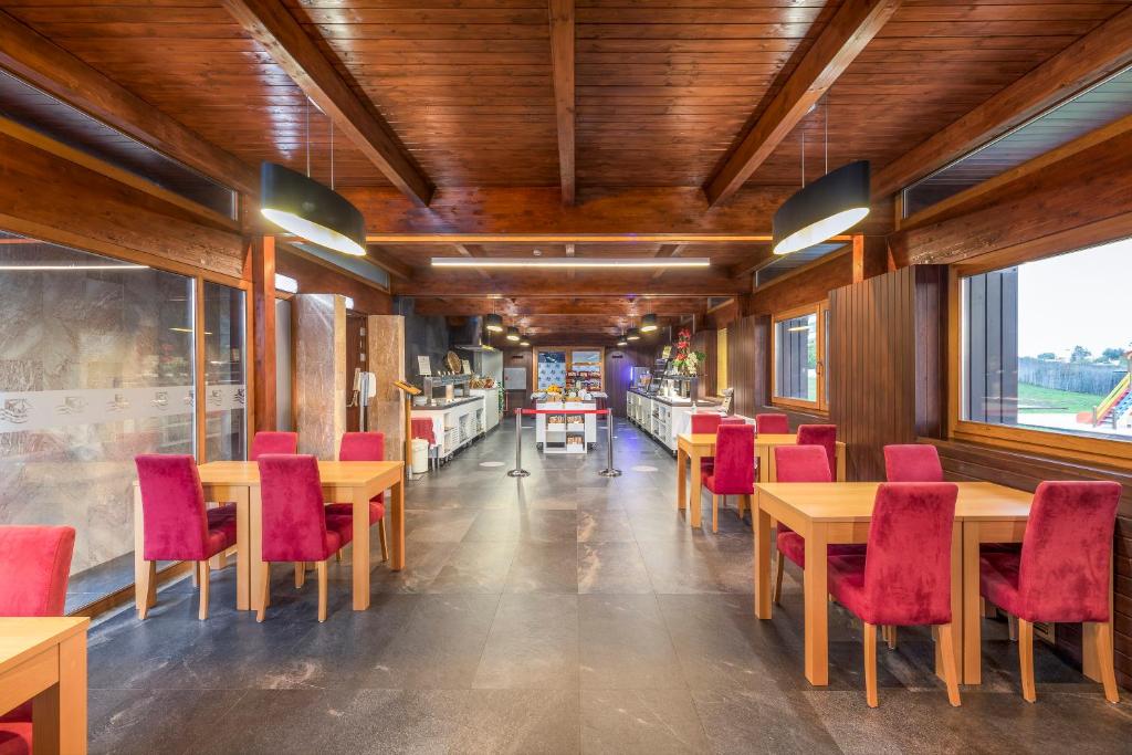 a dining room with tables and red chairs at Interpass Vau Hotel Apartamentos in Portimão