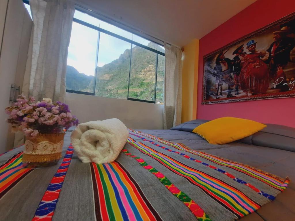 a bedroom with a bed with a large window at Hostal Raymi in Ollantaytambo