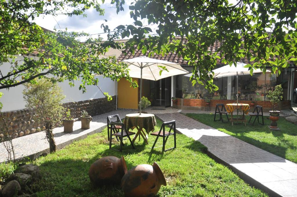 un patio con mesa, sillas y sombrilla en Hostal Goya Andina, en Cusco