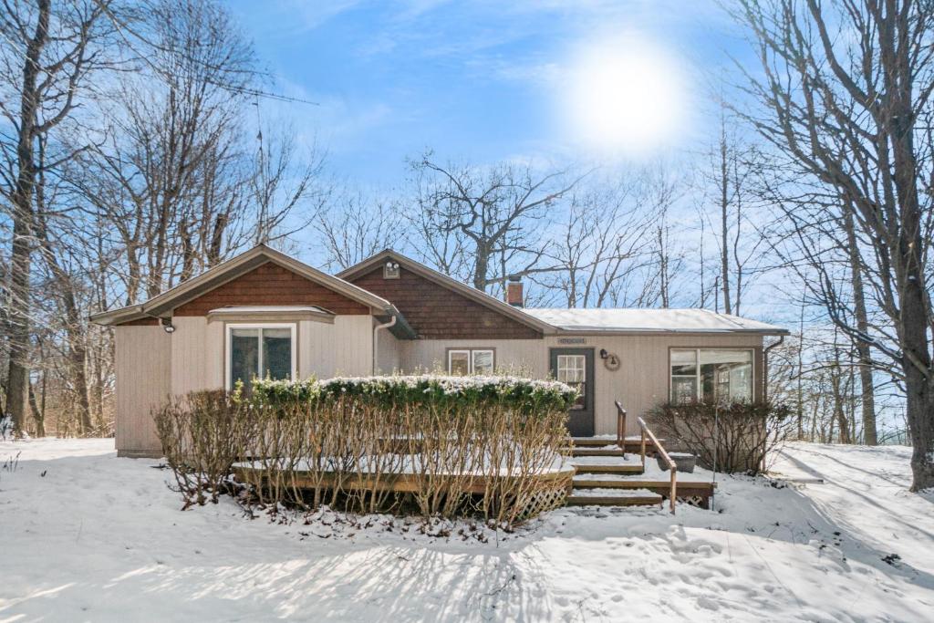 a house in the snow with the sun behind it at Johnson Cottage in Glenn